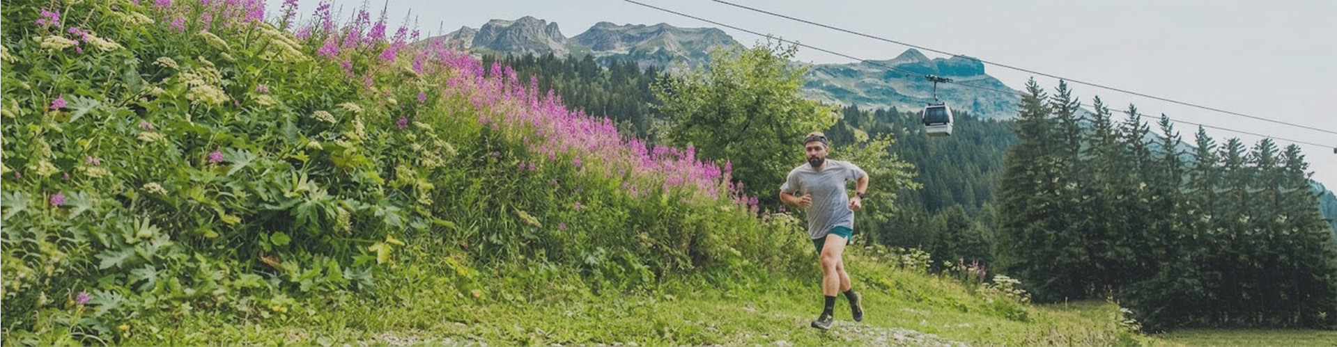 Trail à Flaine : coureur sur un sentier fleuri avec la télécabine des Grandes Platières en arrière-plan.